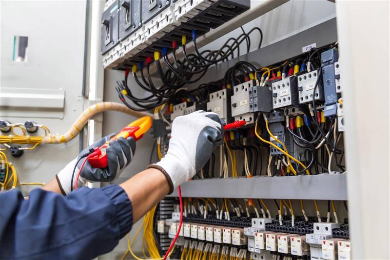 Electrician working on consumer unit — FlowSafe HomeCare